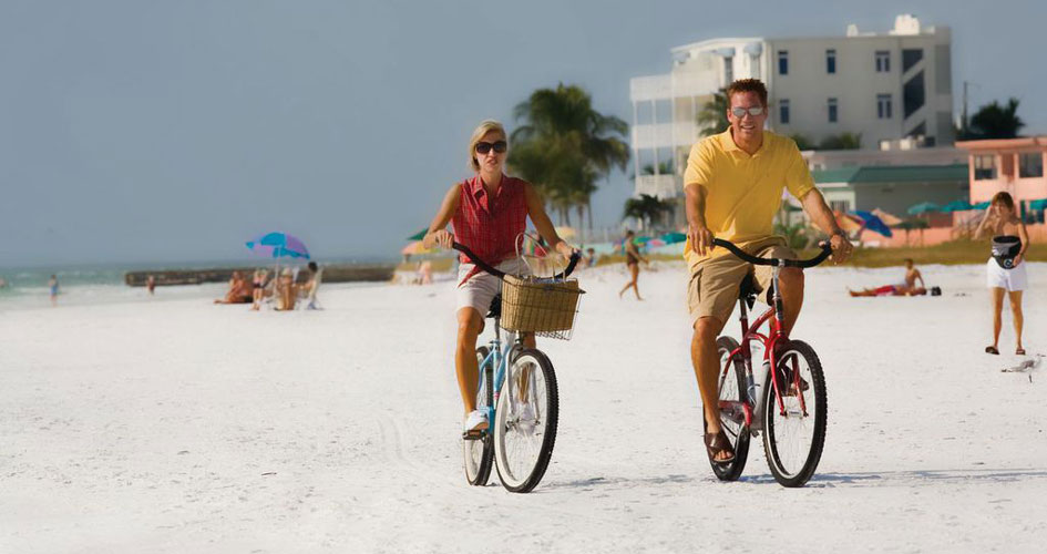 Siesta Key couple riding bicycles on beach